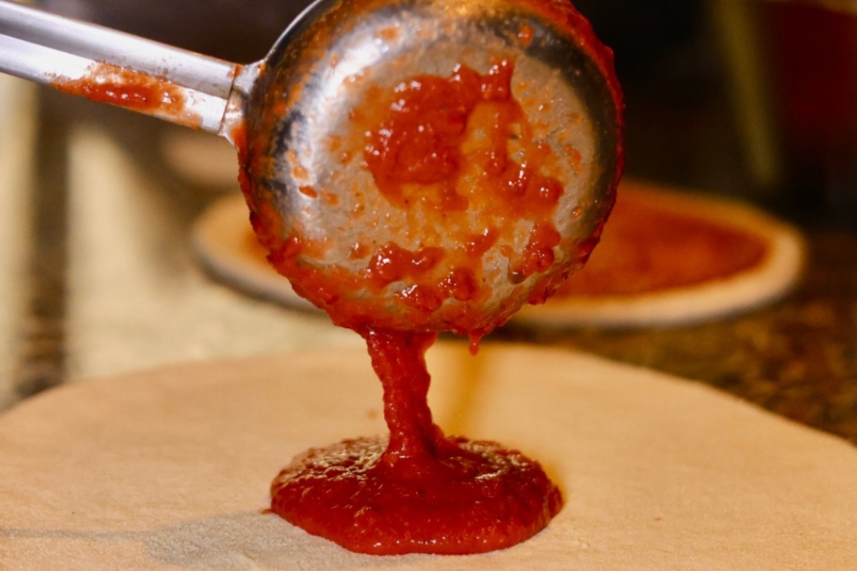 photo-tomate photo de sauce tomate versée sur une pizza